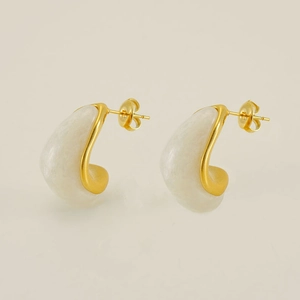 Détail de boucles d'oreilles plaquées or 18 carats avec un insert en résine blanche
