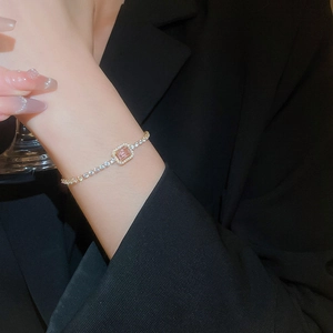 Detail of pink rectangle zircon bracelet with pavé diamonds worn by model on wrist