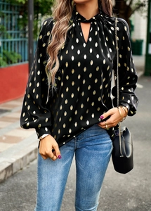 Detail view of women's black long sleeve blouse with gold polka dots and halter neckline