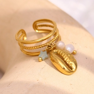 Detail of 18K gold plated multi-layer ring with cowrie shell, pearls and blue star charms