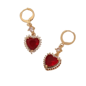 Elegant gold earrings with red heart gemstone and sparkling crystal halo on white backdrop