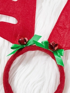 Detail of Christmas reindeer antler headband with red bells and green satin bows