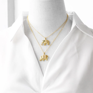 Detail of layered elephant pendant necklaces with zircon inlay on a model mannequin
