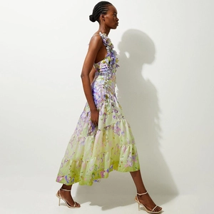 Detail of light green floral maxi dress with 3D flower shoulder accents and tiered skirt