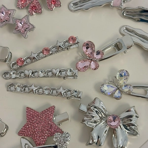 Detailed view of silver hair clips set with pink rhinestones and butterfly star shapes