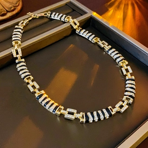 Detailed shot of golden link necklace with black leopard print inlay and crystals