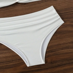 Detail of white ribbed bikini bottoms showing high waist texture and soft fabric