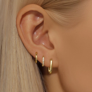 Detailed close-up of a 3-piece gold S925 silver earring set with crystals on ear