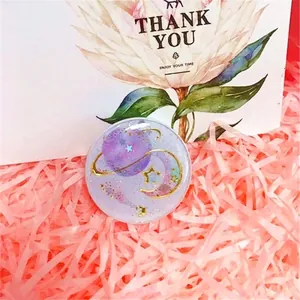 Macro detail of starry moon resin phone grip with golden stars and glitter finish