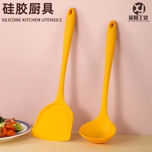 Detail of yellow silicone kitchen utensil set featuring a soup ladle and spatula
