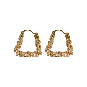 Golden U-shaped twisted hoop earrings with zircon pavé setting on a white background