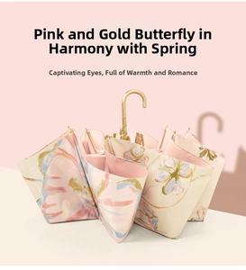 Detail of elegant gold butterfly pattern and metallic handle on premium floral umbrella
