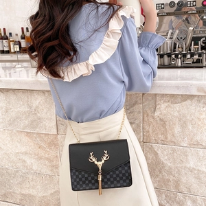 Detail of black crossbody bag with gold deer hardware and vintage mesh texture