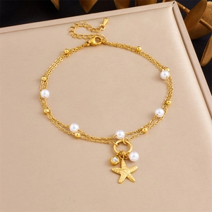 Detail of gold-plated starfish anklet with white pearls and sparkling zircon on satin