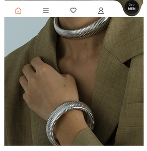 Polished silver rib-textured collar necklace and chunky bracelet set worn with a suit