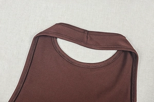 Détail de l'encolure et des coutures d'une robe moulante marron foncé en tissu élastique