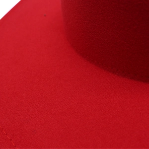 Detailed close-up of the red wool felt hat showcasing the fine texture and neat stitching