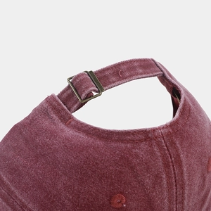 Detail of washed red corduroy cap with adjustable metal buckle and embroidery eyelets