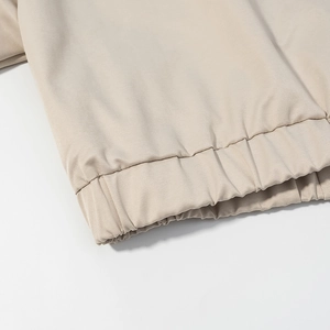 Detail of elastic hem on beige twill jacket with sharp focus on stitching and fabric