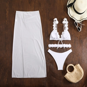 Detailed view of white bikini three-piece set with mesh skirt and 3D floral accents