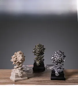 Detailansicht von drei Löwenkopf-Skulpturen in Sandstein-, Bronze- und Silberoptik