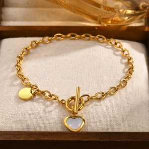 Detail of gold heart charm bracelet with pearl shell inlay and secure OT toggle clasp