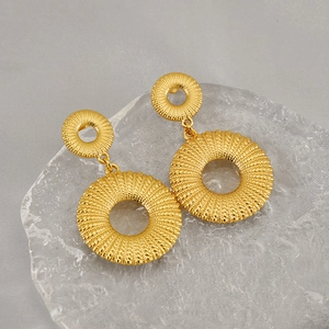 Detailed view of 18K gold plated stainless steel hoop earrings with woven spiral texture