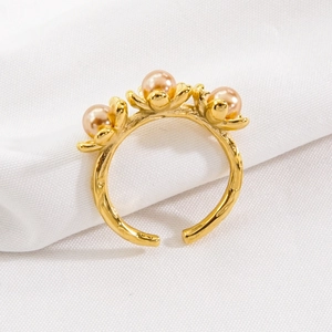 Elegant gold titanium steel ring featuring three flower designs with champagne pearls