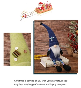 Detail of blue plush Christmas gnome with striped legs and button accents on green fabric
