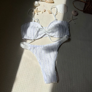 Detaillierte Makroansicht von weißem Seersucker-Bikini-Top mit Schleife und Seestern-Deko