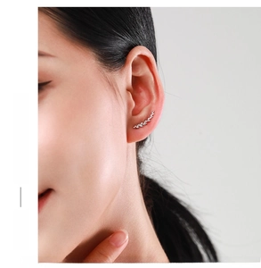 Close-up of S925 sterling silver leaf ear crawler on female model's ear