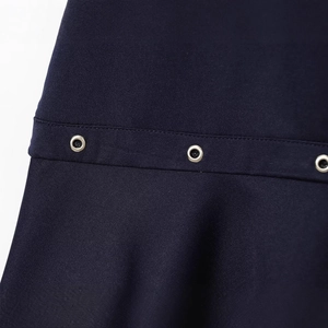 Detail of navy blue dress featuring metal eyelets and precision stitching on twill fabric