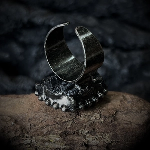 Detail of vintage silver adjustable ring with irregular texture and dark gothic aesthetics