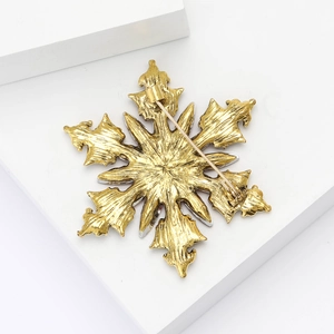 Macro shot of gold snowflake brooch back detail with metal texture and pin clasp