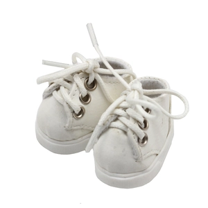 Close-up of white canvas doll shoes with silver metal eyelets and white laces