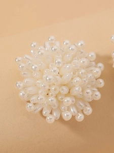 Macro shot of elegant white faux pearl flower cluster stud earring with silver needle