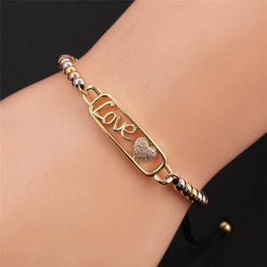 Dettaglio del bracciale con barra Love placcata oro e cuore in zircone su corda