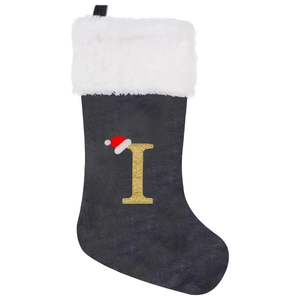 Detail of grey velvet Christmas stocking with a golden glitter letter I and faux fur cuff