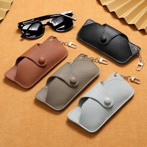 Close-up of four leather sunglasses cases with metal hooks and snap closure in various colors