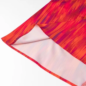 Nahaufnahme von rotem Boho-Stoff mit lila Streifen und hochwertiger Saumverarbeitung