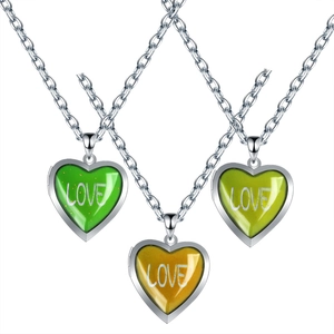 Close-up of heart-shaped mood pendants in green and yellow with LOVE inscription