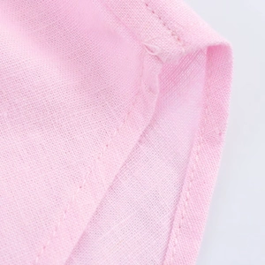 Close-up of pink linen fabric texture with professional double-stitched hem detail