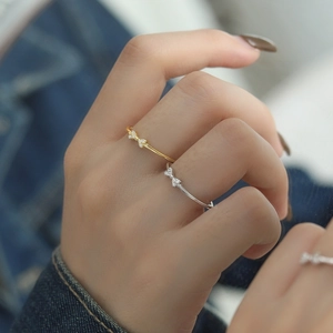 S925 Sterling Silver Bow Ring with Zirconia stones on a model's hand in silver and gold