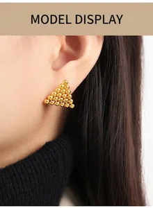 Detailed view of gold geometric ball cluster earrings worn on ear for a vintage look