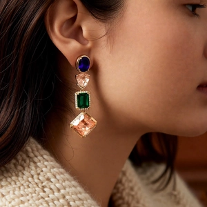 Close-up of vintage dangle earrings with colorful zircon gemstones on elegant model