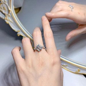 Primer plano de un elegante anillo cruzado con piedra central redonda y pavé de diamantes