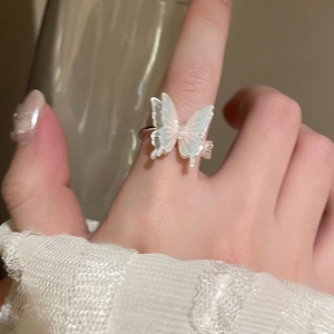 Close-up of elegant silver butterfly ring with iridescent wings on finger