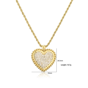 Golden heart pendant necklace with pave-set zircons and rope chain detail on white background