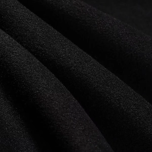 Gros plan du tissu en daim noir montrant la texture douce et la qualité de la matière