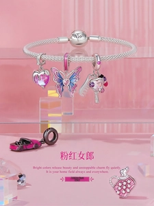 Detailed macro of S925 silver charm bracelet with pink butterfly and car pendants